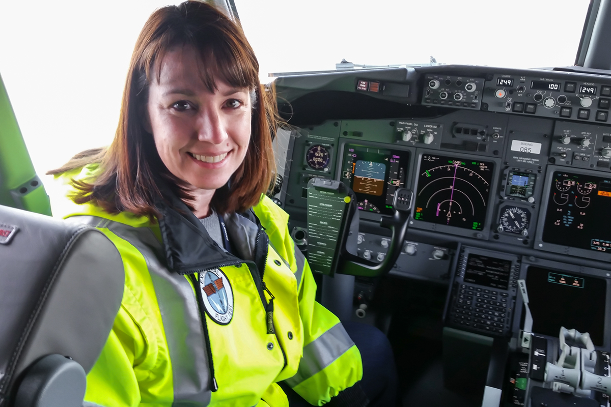 Kerry sitting in the cockpit of a Boeing 737 airplane.