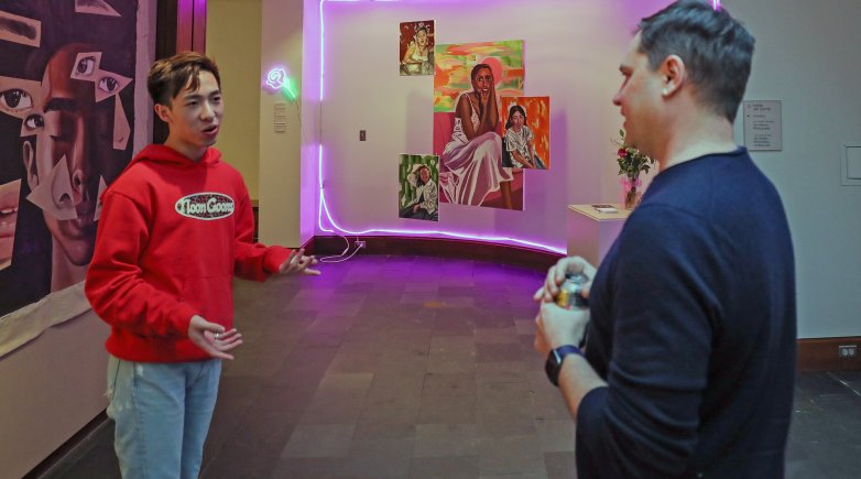 Justin Li and M. Sharkey discuss Li's artwork in the foyer of the Lamont Gallery.